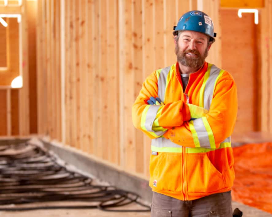 A construction worker who uses Xero’s accounting software, looking happy on a building site.