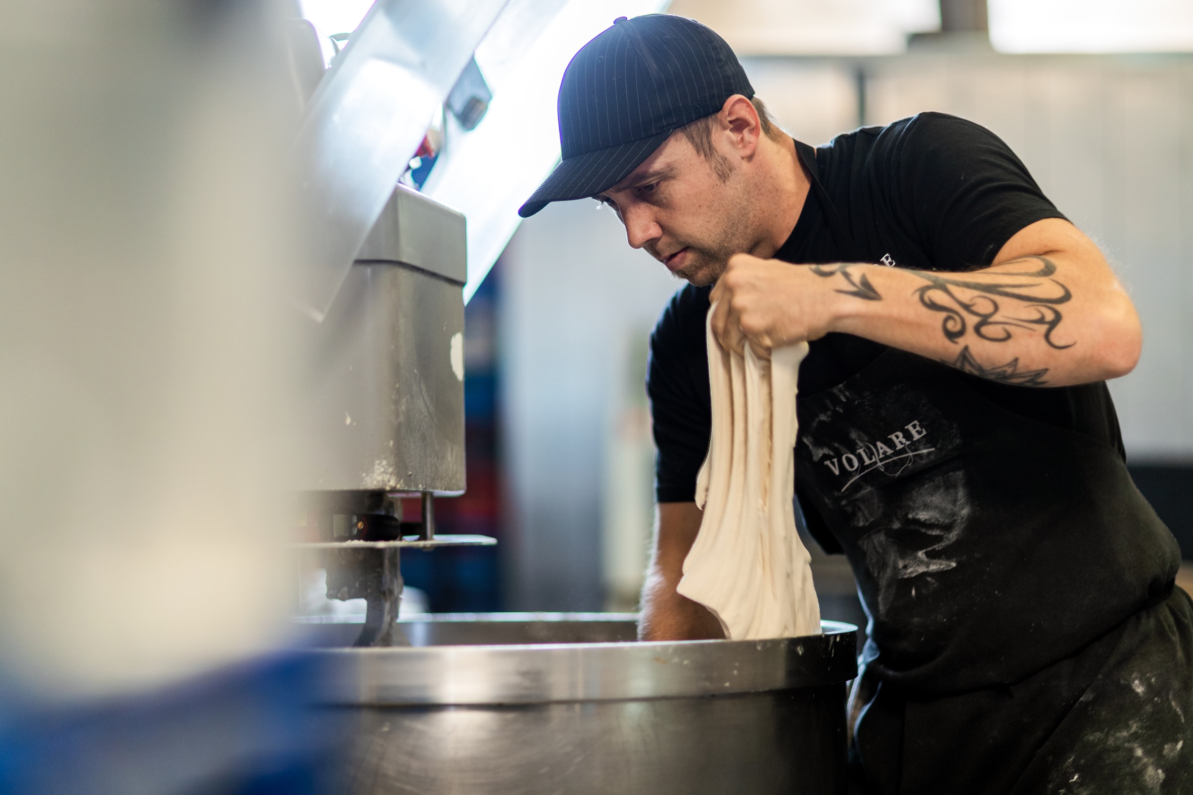 A baker kneads dough at a bakery.