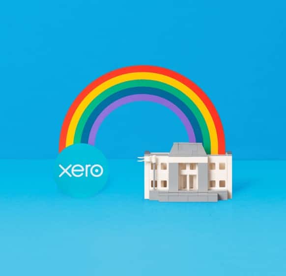 A rainbow connects a Xero logo to a bank building.